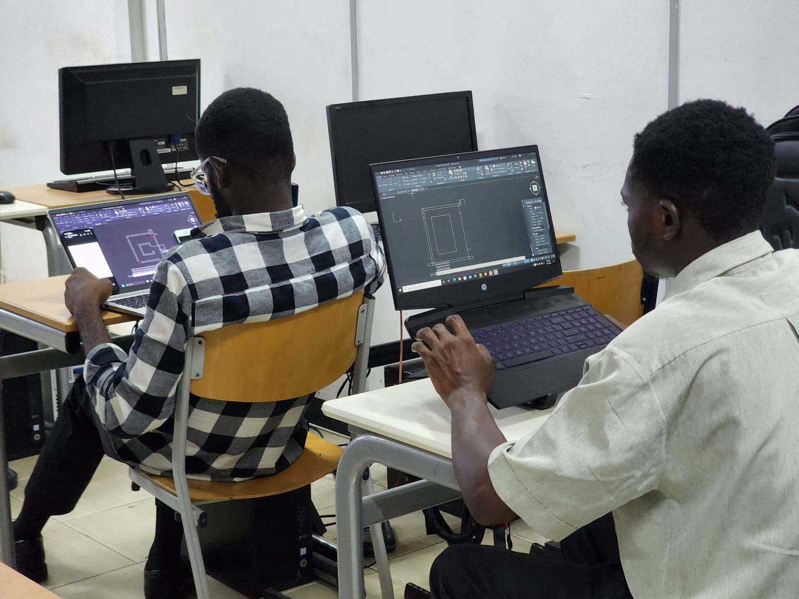 Adult students at laptops during an IT training session in Accra